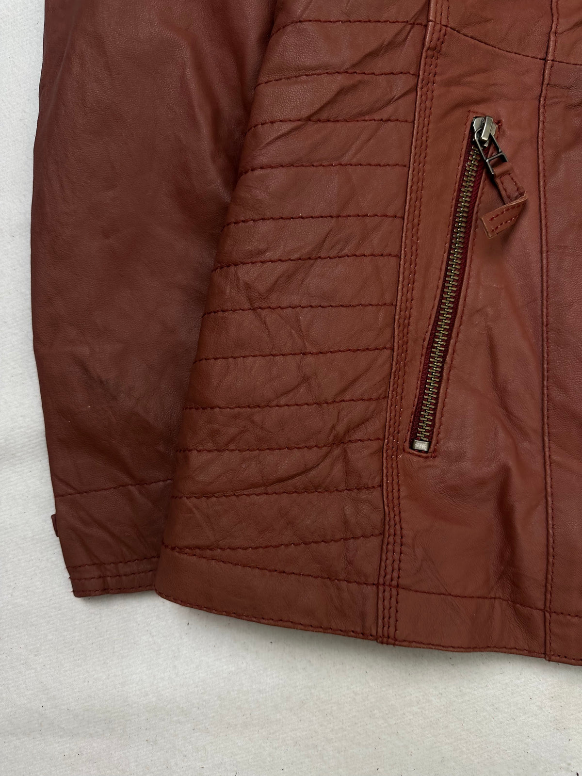 Close detail of the pockets and cuff on the size XL burgundy leather vintage jacket