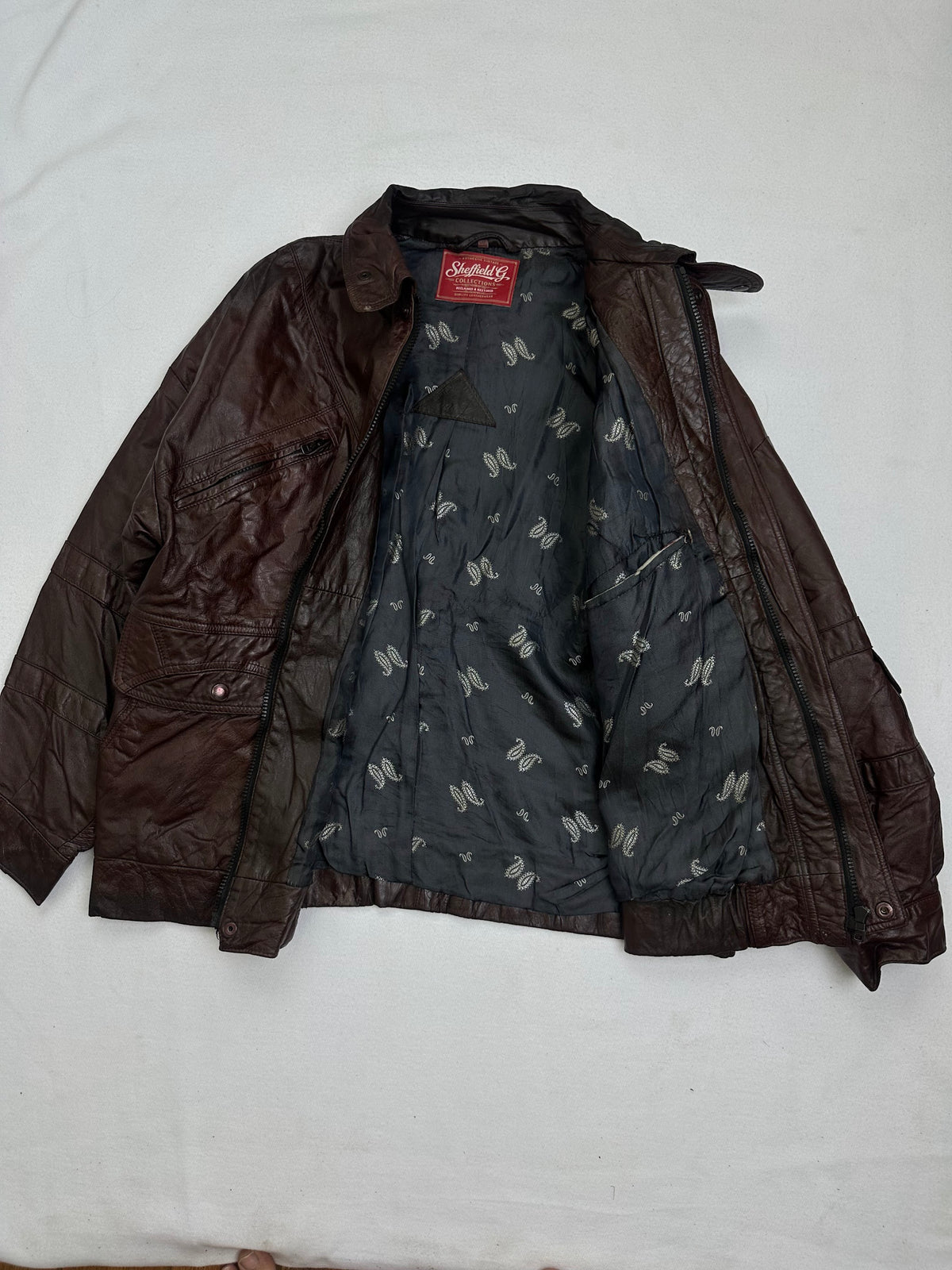 The size M burgundy leather flight jacket opened to show the lining