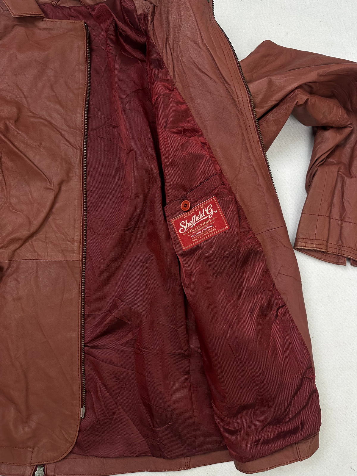 The size XL burgundy leather vintage jacket opened to show the lining