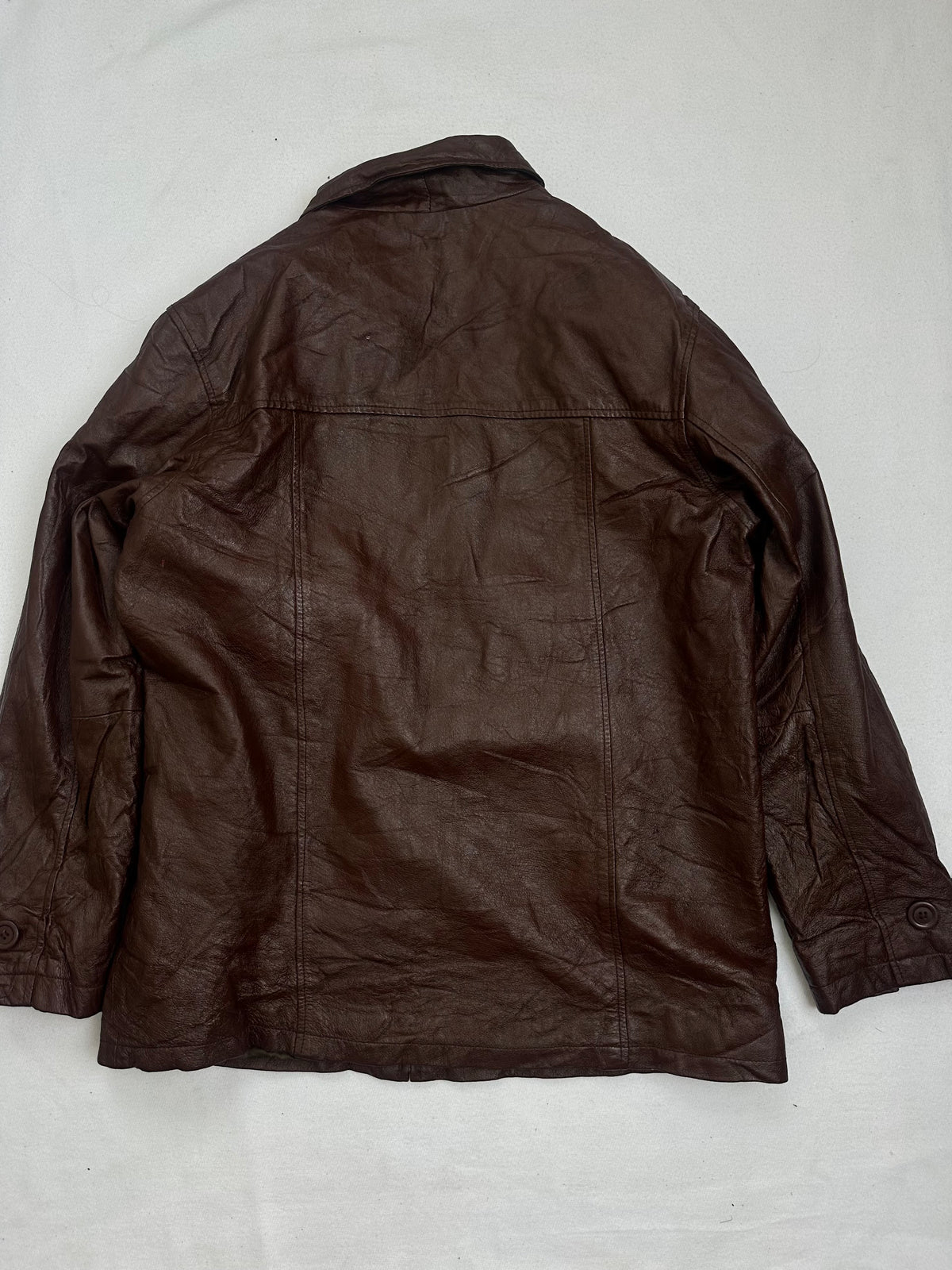 Back of the size L burgundy leather vintage jacket, laid flat