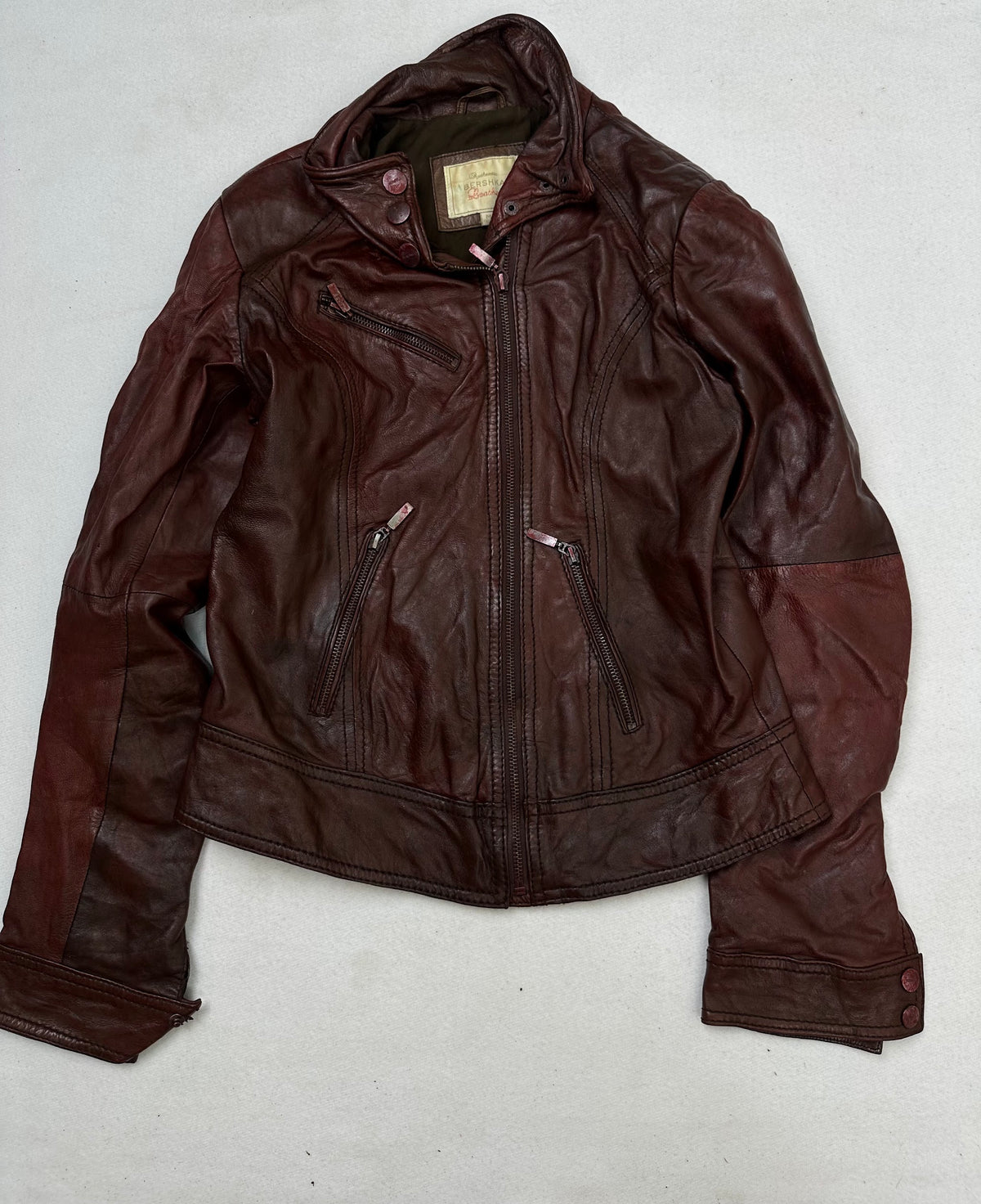 Front of the size S burgundy leather cafe racer jacket, laid flat and unedited