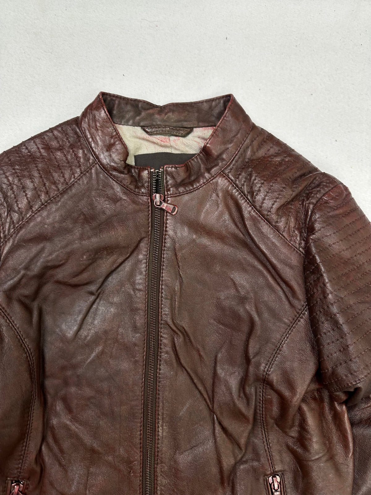 Collar and zip of the size XS burgundy leather cafe racer jacket, up close