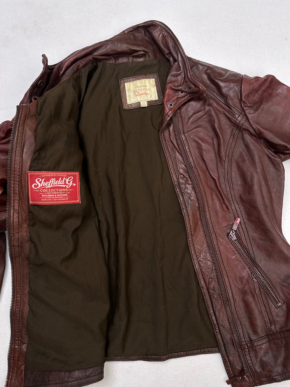 The size S burgundy leather cafe racer jacket opened to show the lining