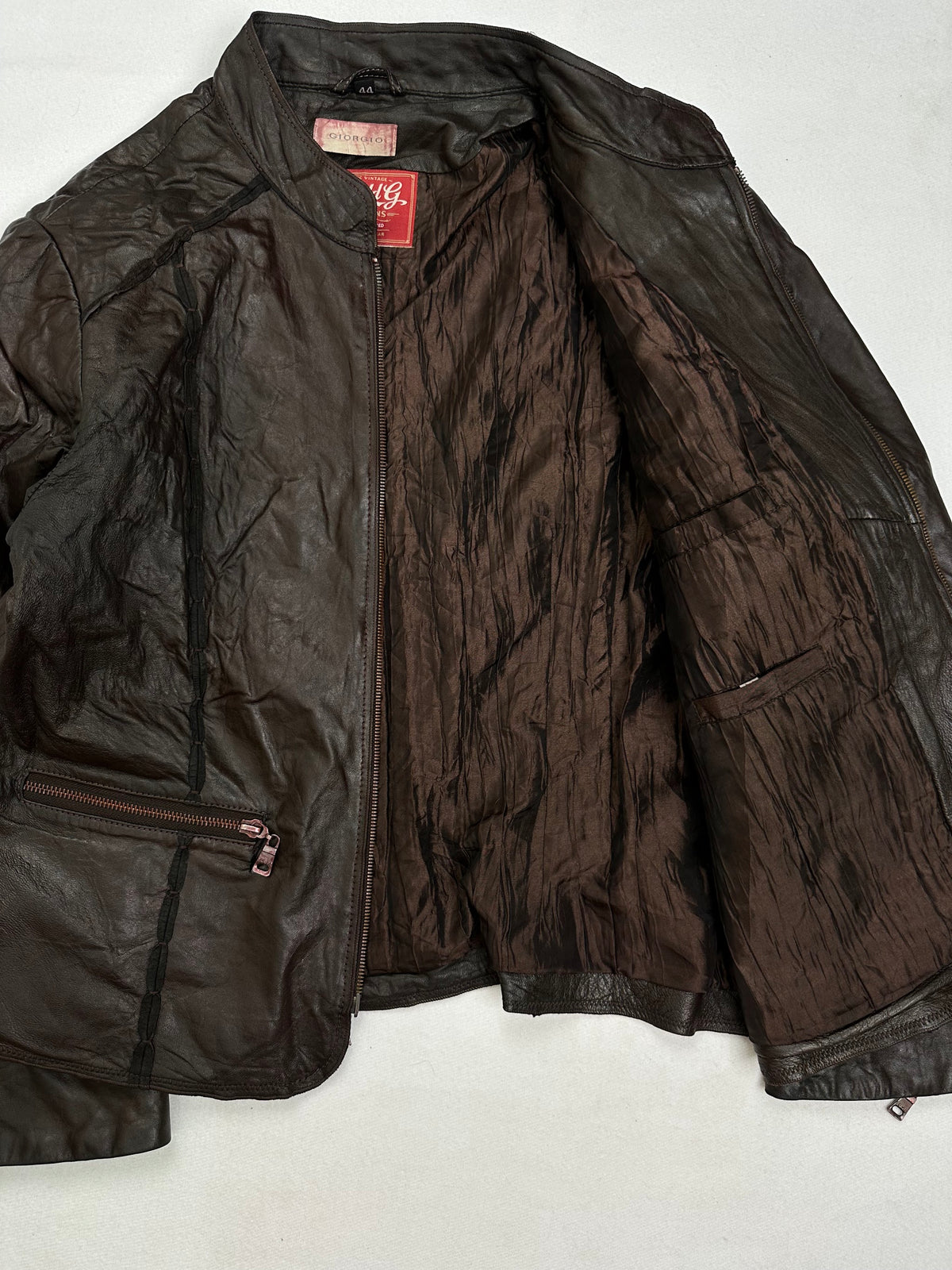 The size S brown leather cafe racer jacket opened to show the lining
