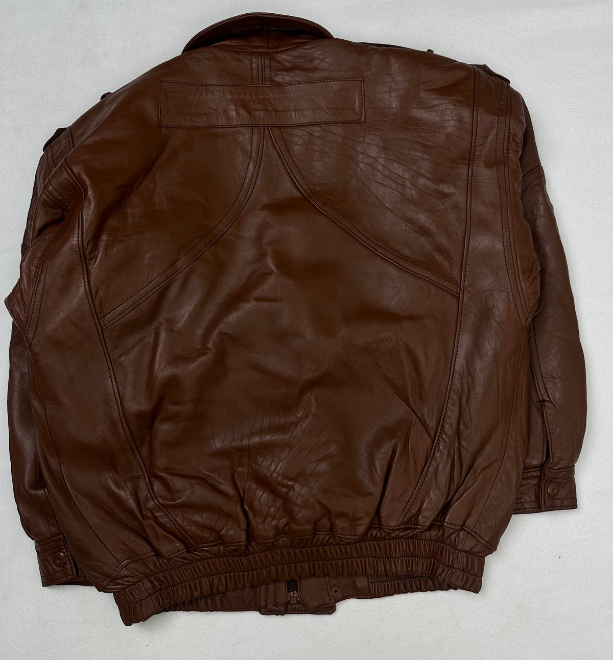 Back of the size L brown leather flight jacket, laid flat