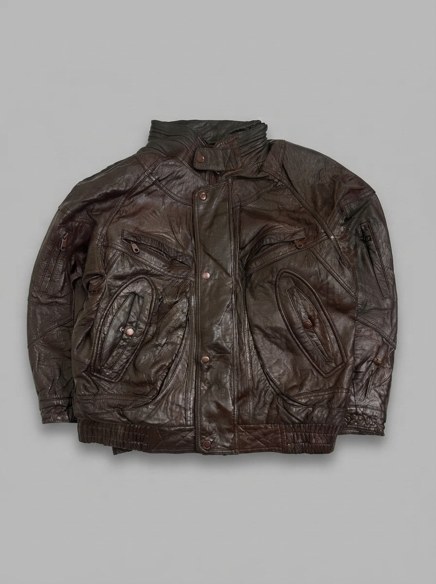 Brown leather jacket laid flat, gathered funnel collar with throat strap and a copper snap storm placket