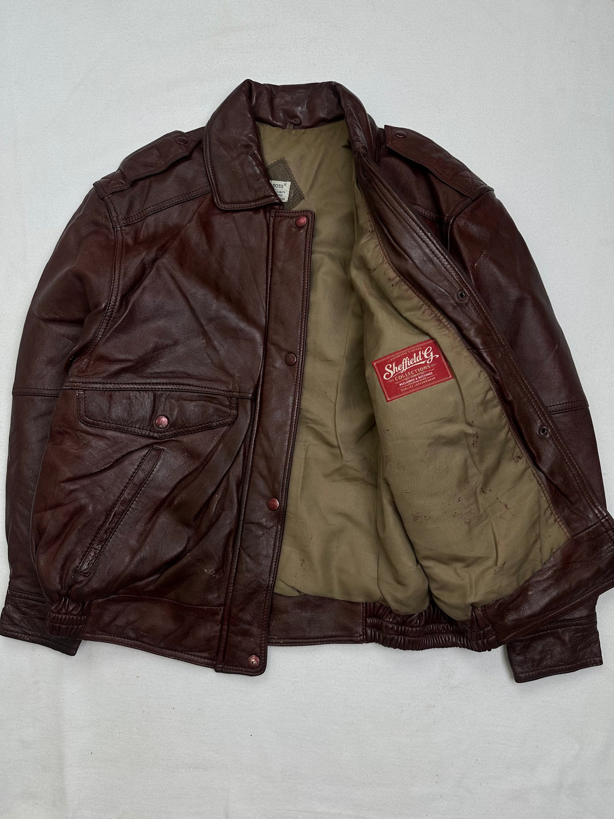 The size L burgundy leather flight jacket opened to show the lining