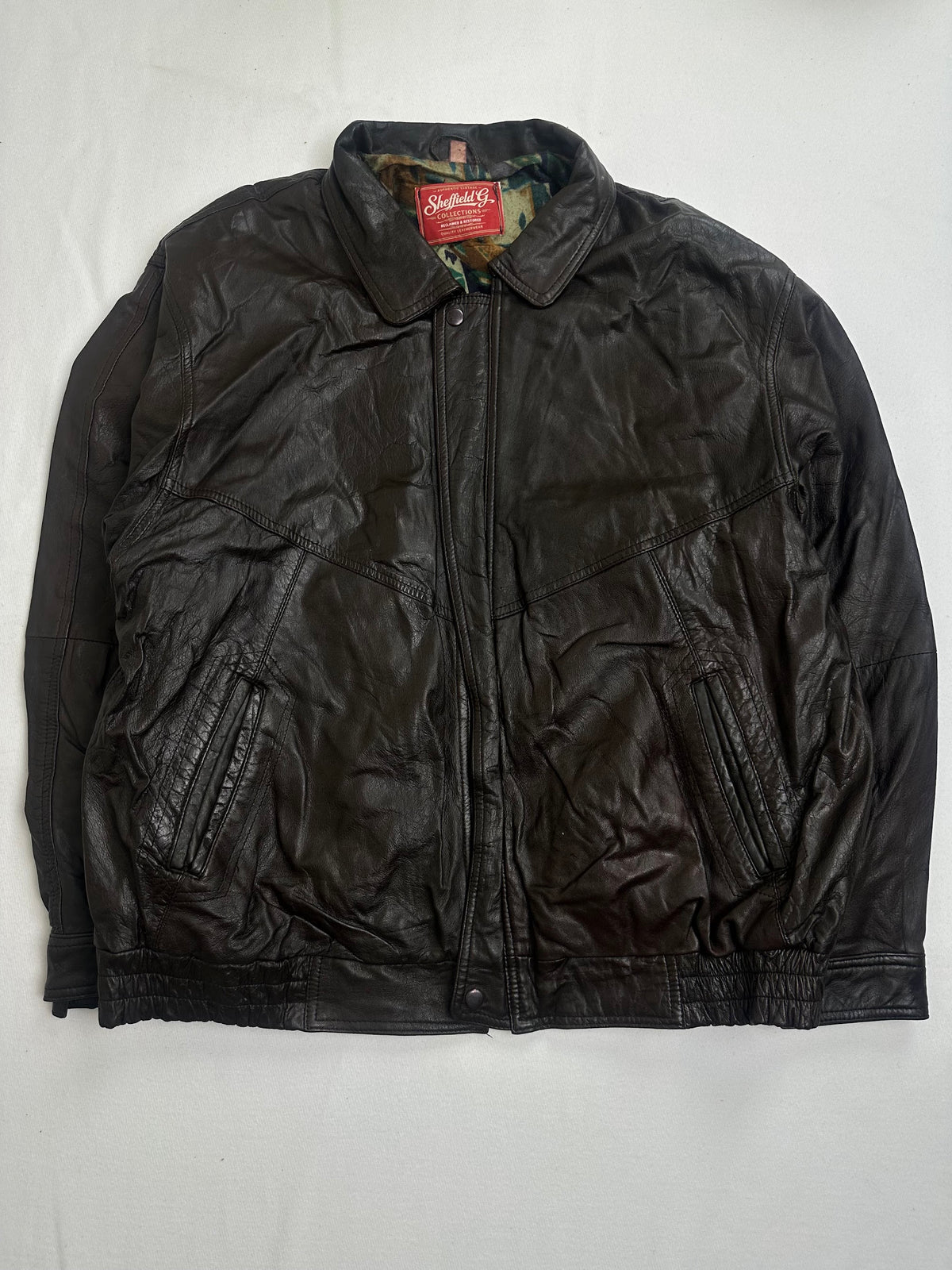 Back of the size L brown harrington jacket laid flat