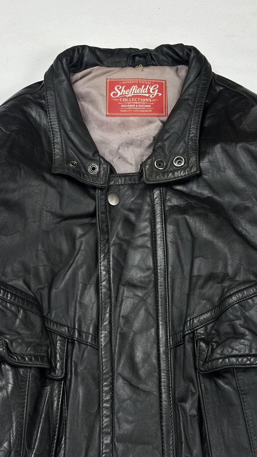 Close view of the stand collar and its twin press studs at the throat