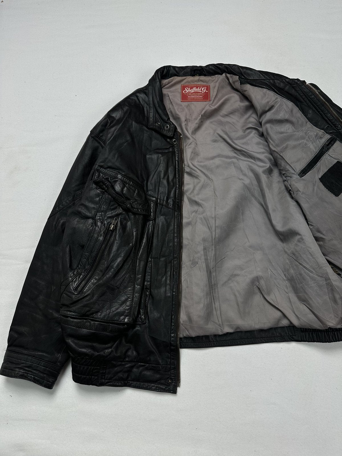 Black jacket held open at an angle to show the grey lining inside
