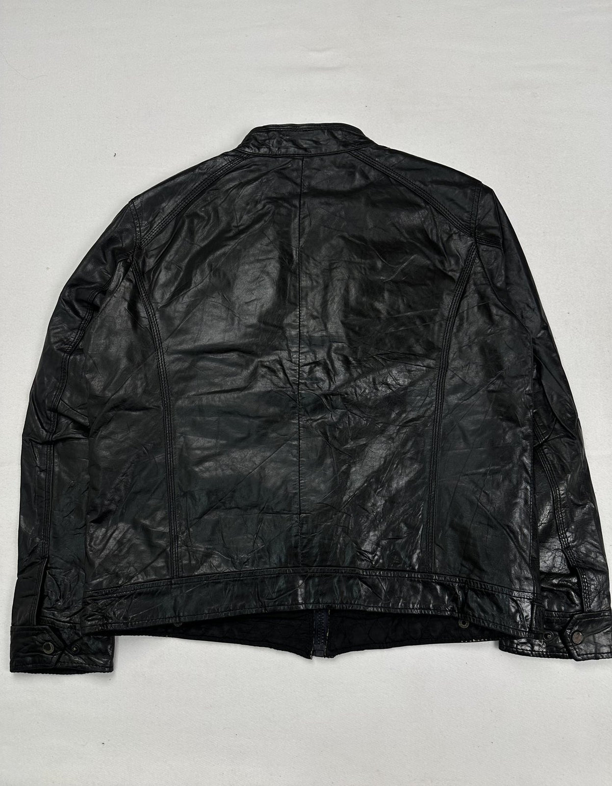 Back of the black leather cafe racer jacket in size XL, laid flat to show the plain panel