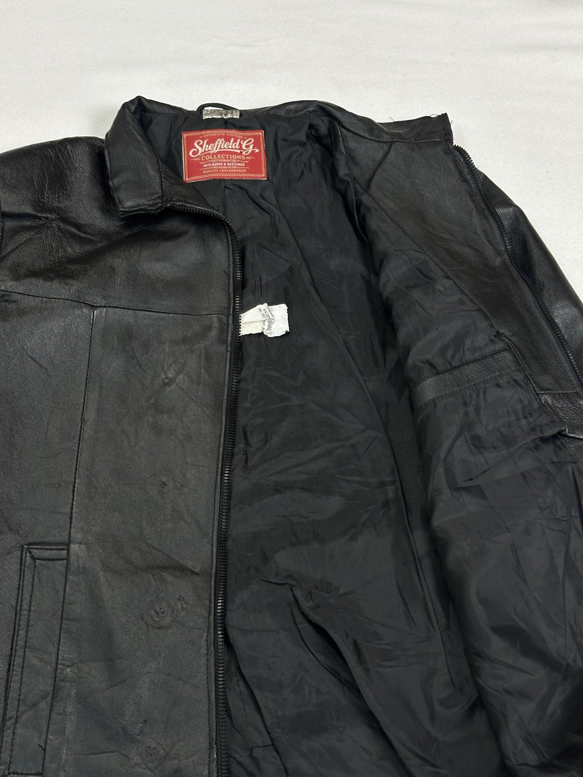 Clean welt pocket openings set flat against the black leather