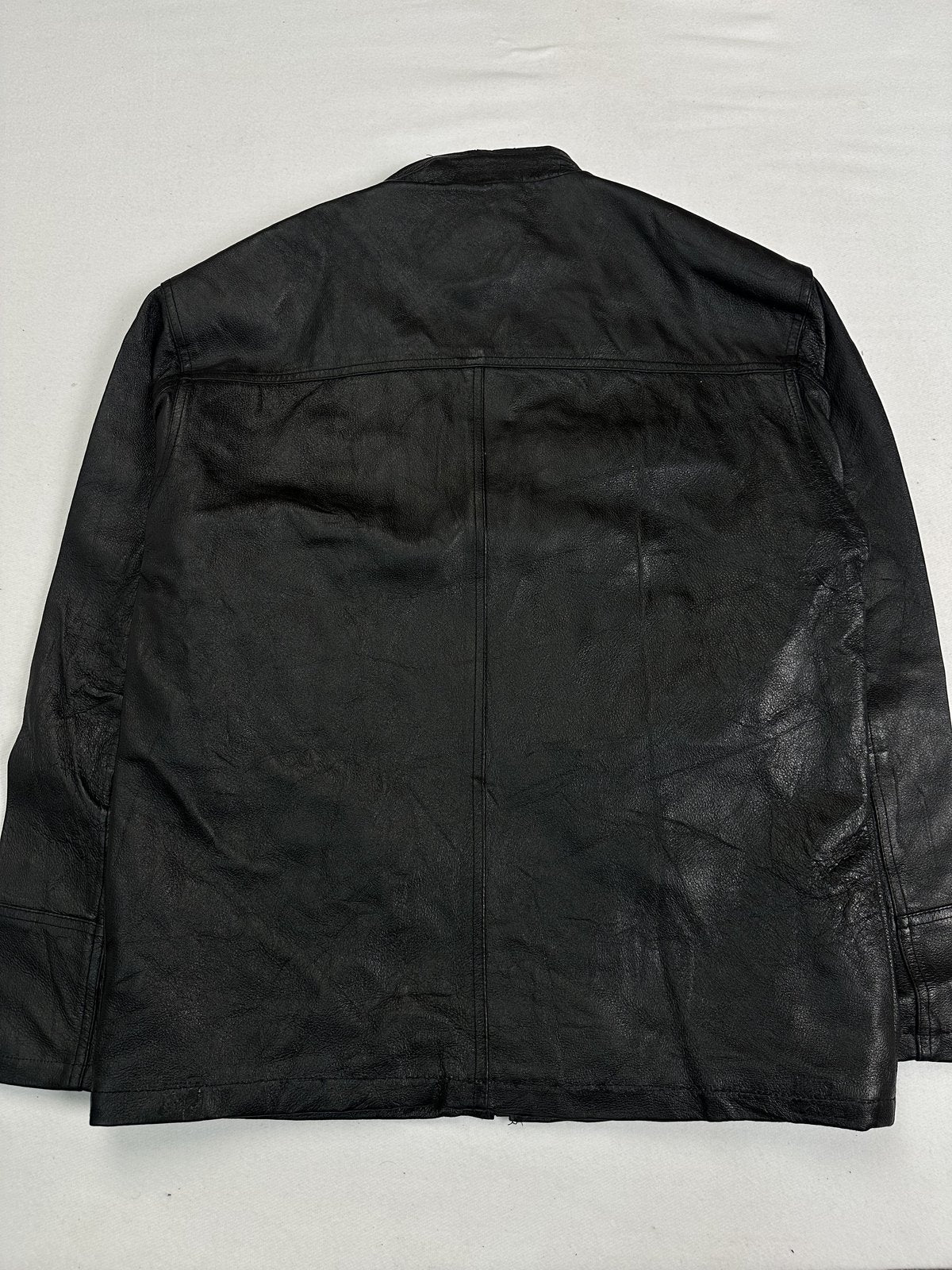Back of the size L black leather jacket laid flat showing the plain panel and yoke seam
