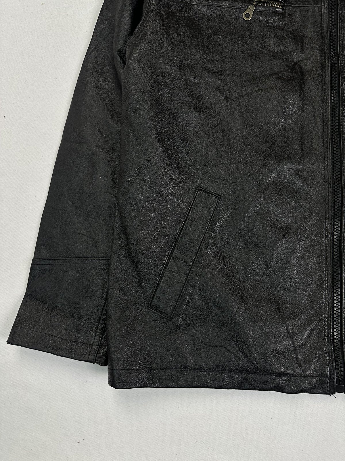 Lower front corner with a welt hand pocket, the cuff and the straight hem