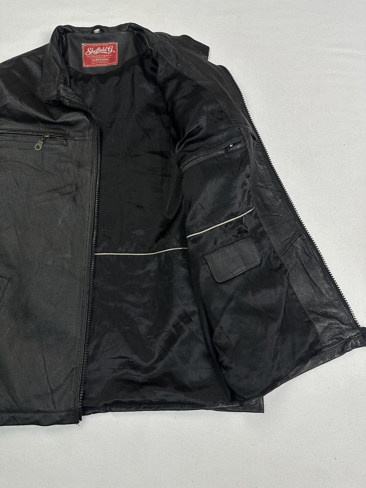 Black lining inside the jacket, held open to show the inner flap pocket at the chest