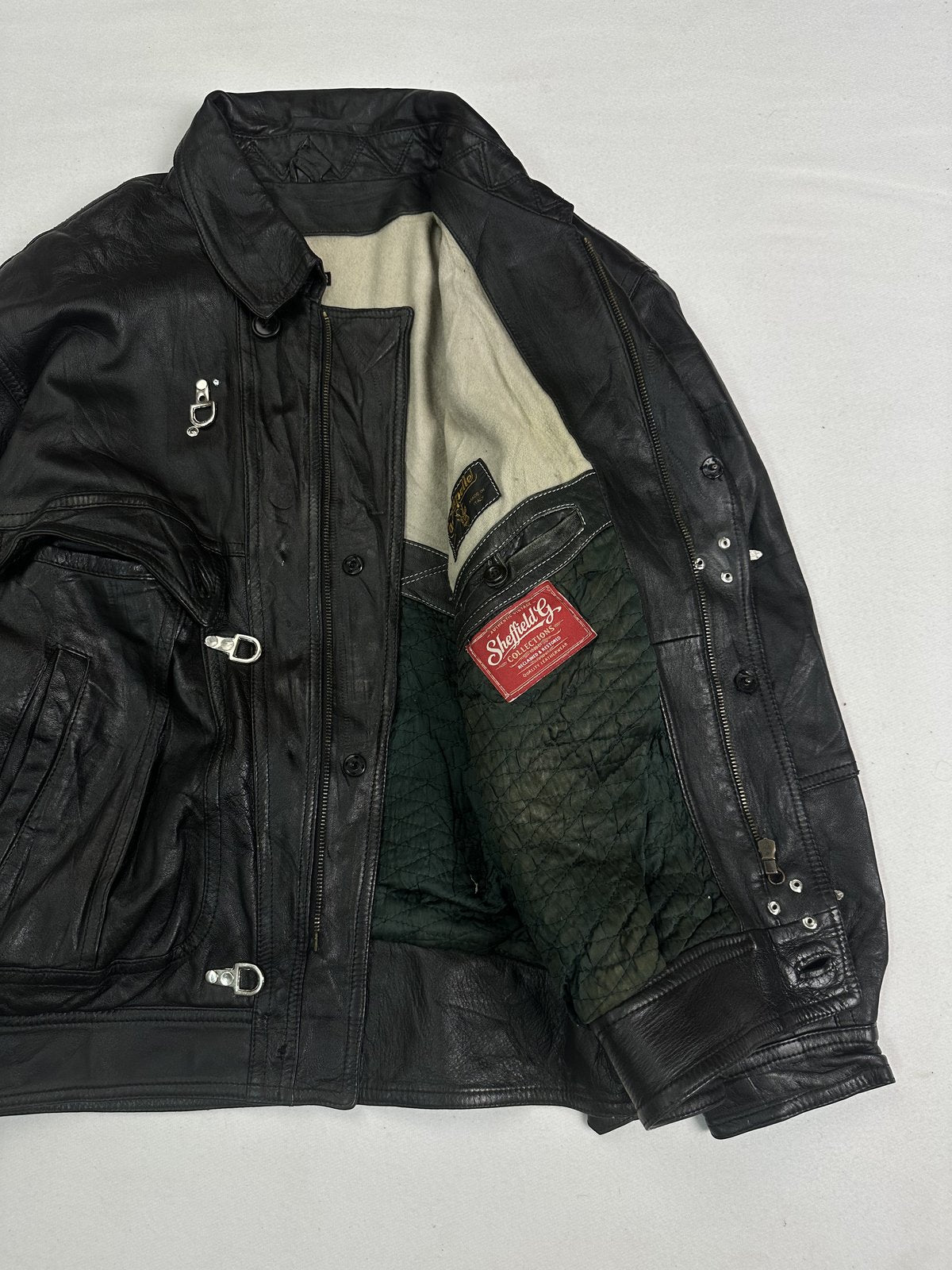 Cafe racer held open to show the dark green quilted lining and cream collar facing