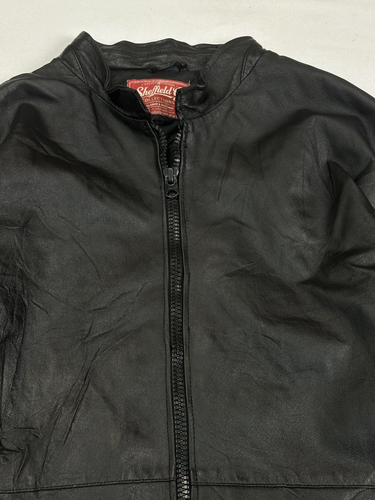 Upper front showing the short mandarin collar and the heavy zip at the neck
