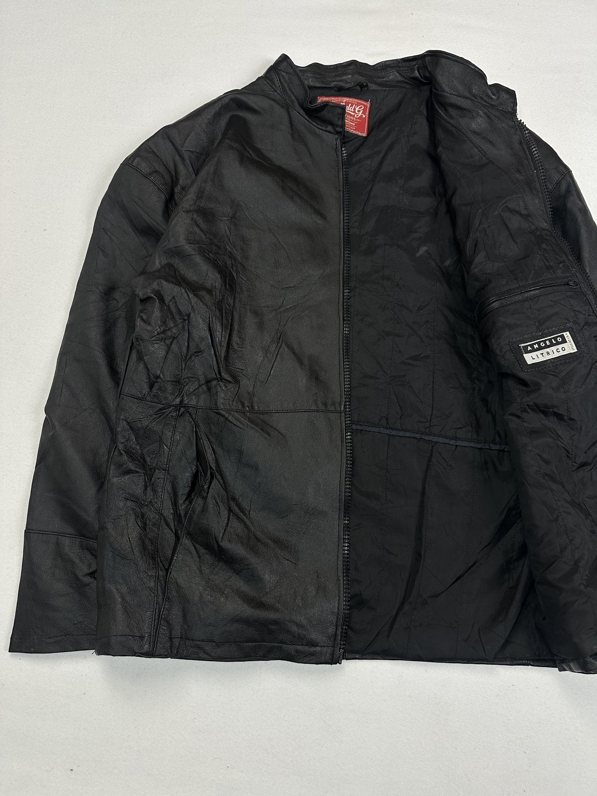 Black jacket held open to show the dark lining and a sleeve pocket