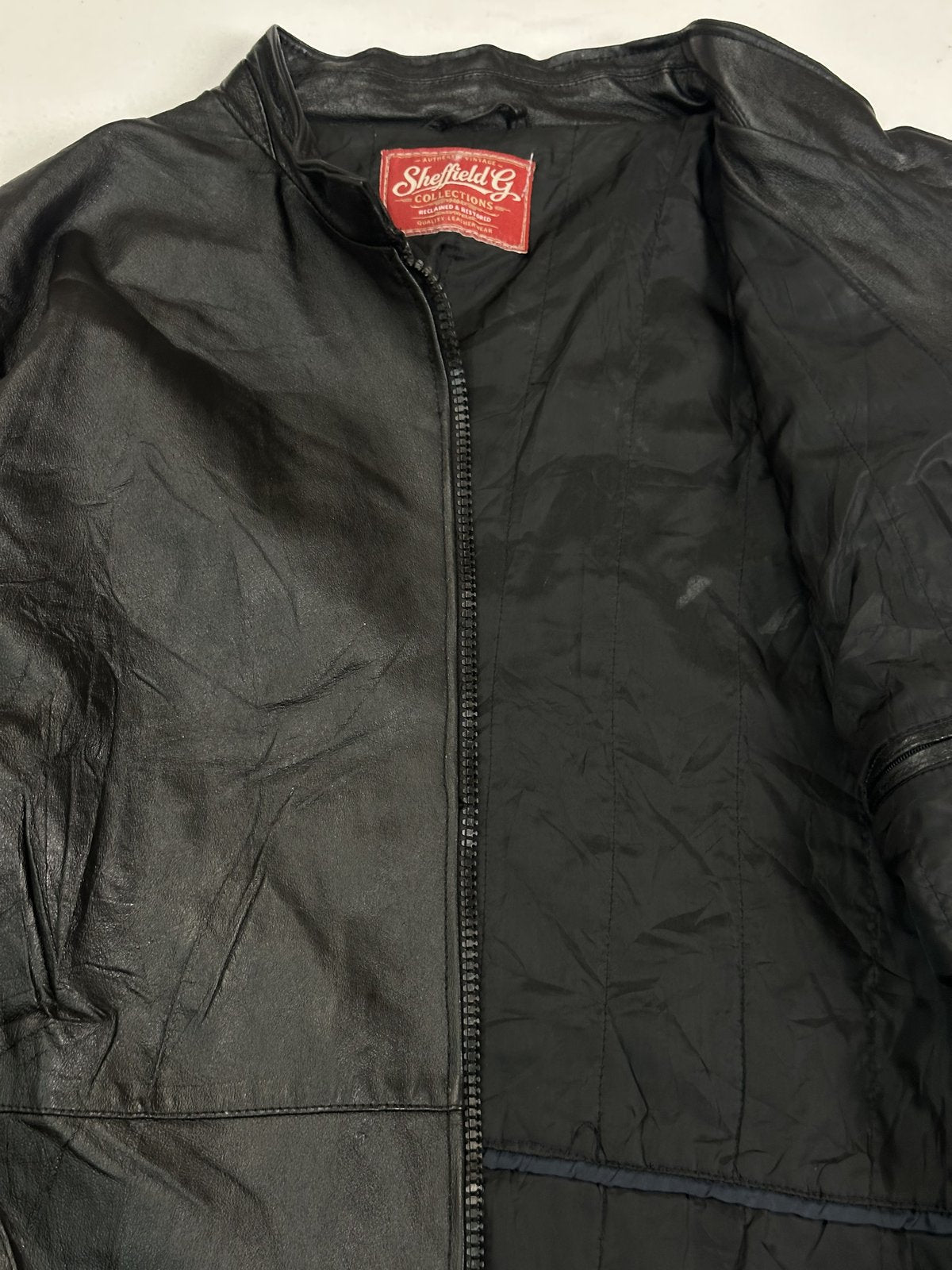 Inner collar and black lining seen close along the open zip