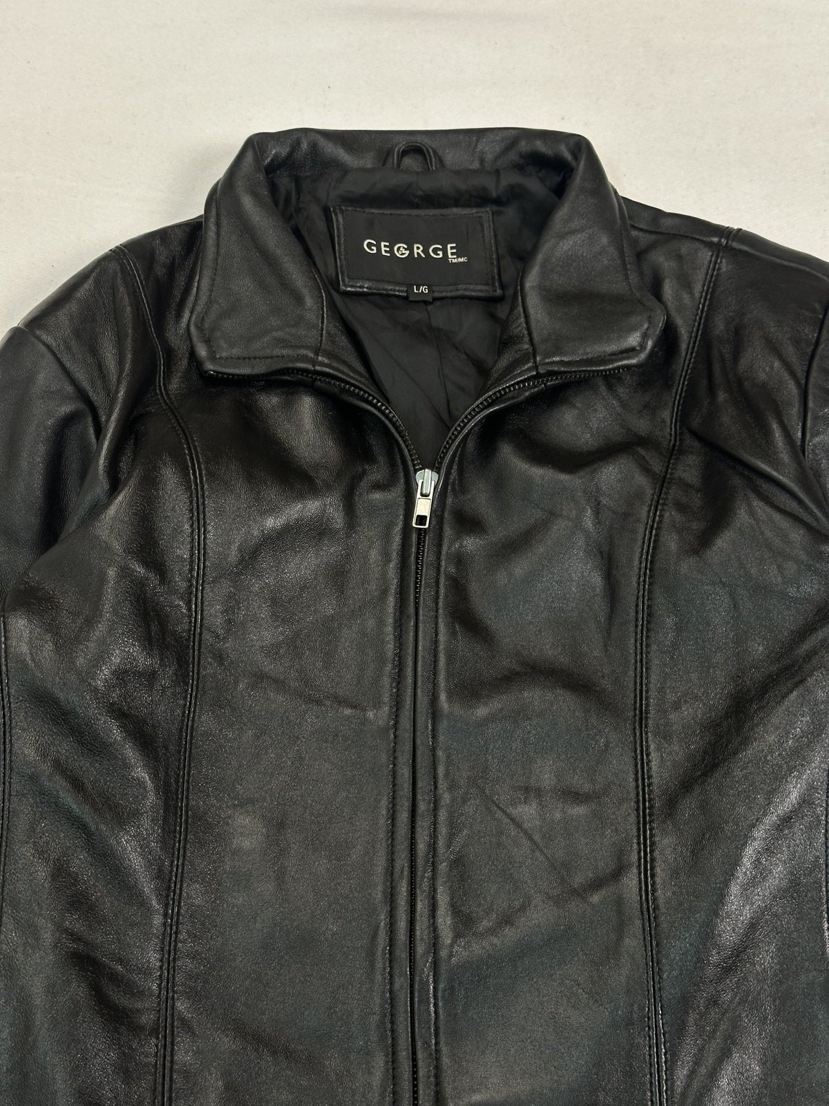 Close view of the fold-over collar standing above the neck of the black jacket