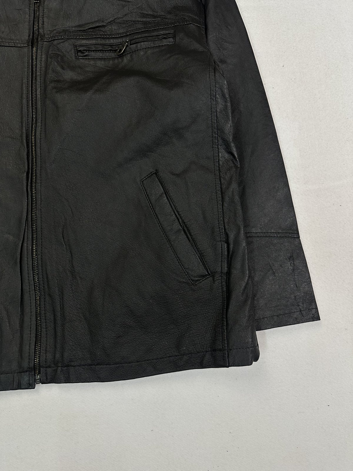 Angled view of the zipped chest pocket, hand pocket and cuff on this vintage black jacket
