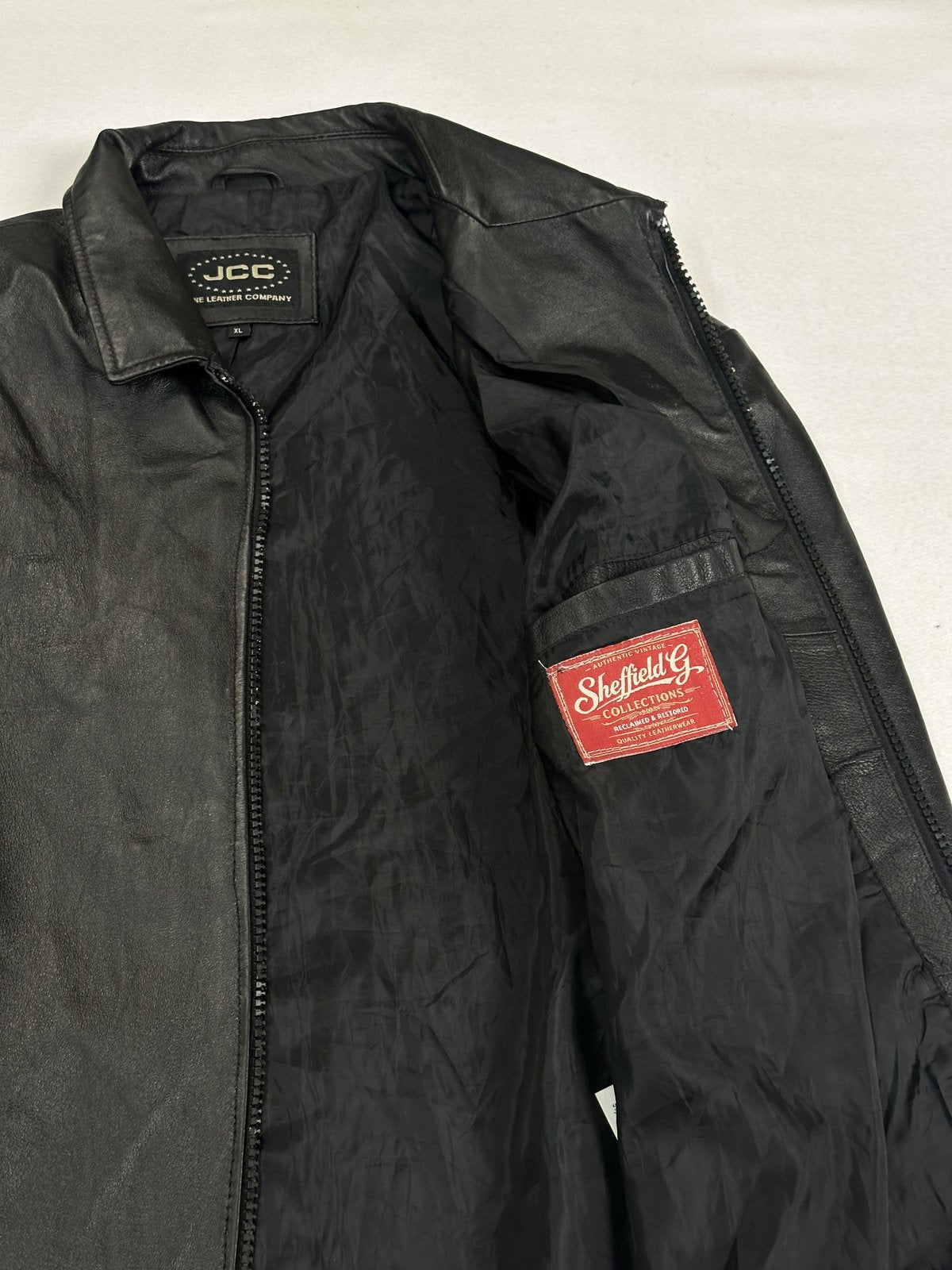 Close view of the interior collar, lining and inner pocket of the black jacket