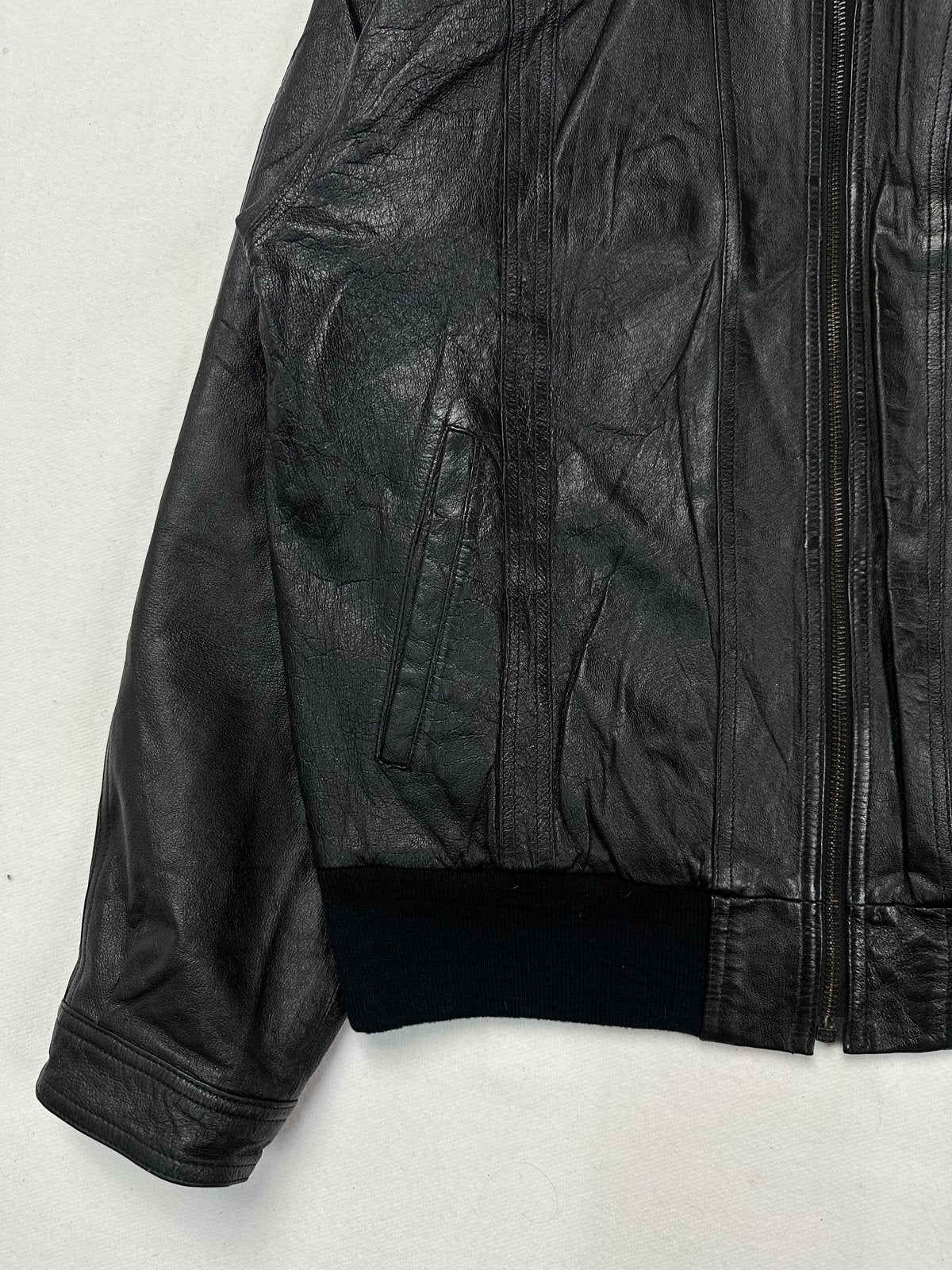 Lower front detail with a welt hand pocket above the ribbed knit hem