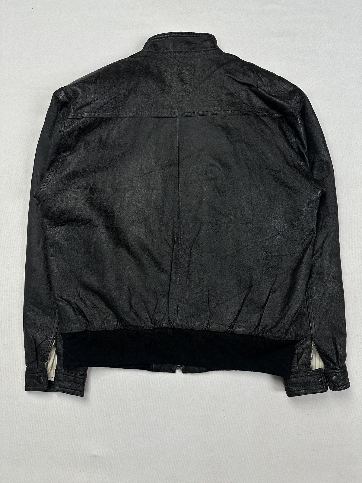 Back of the L black bomber laid flat with the rib hem across the waist