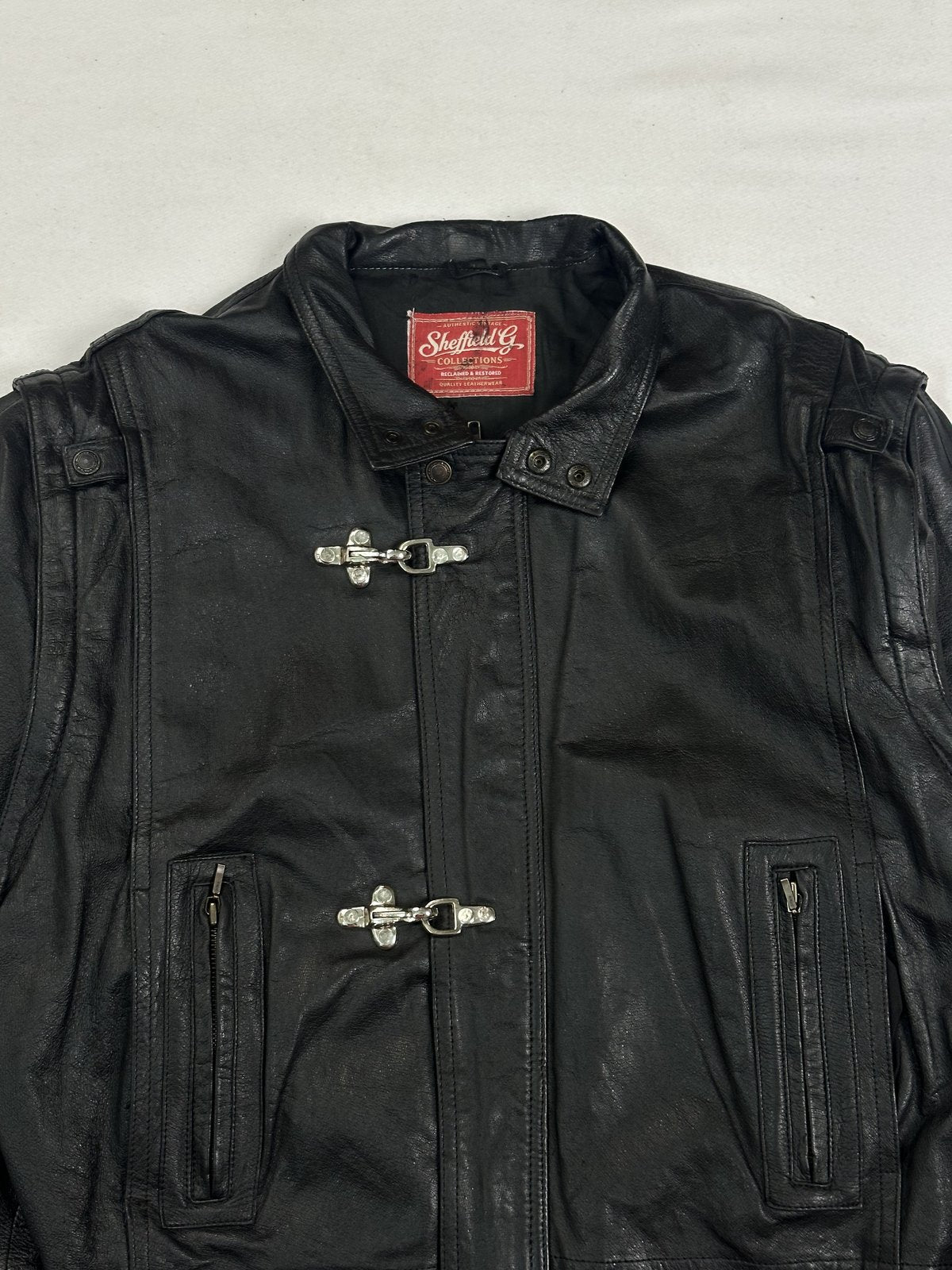 Close view of the stand collar and the shoulder epaulettes on this vintage black jacket