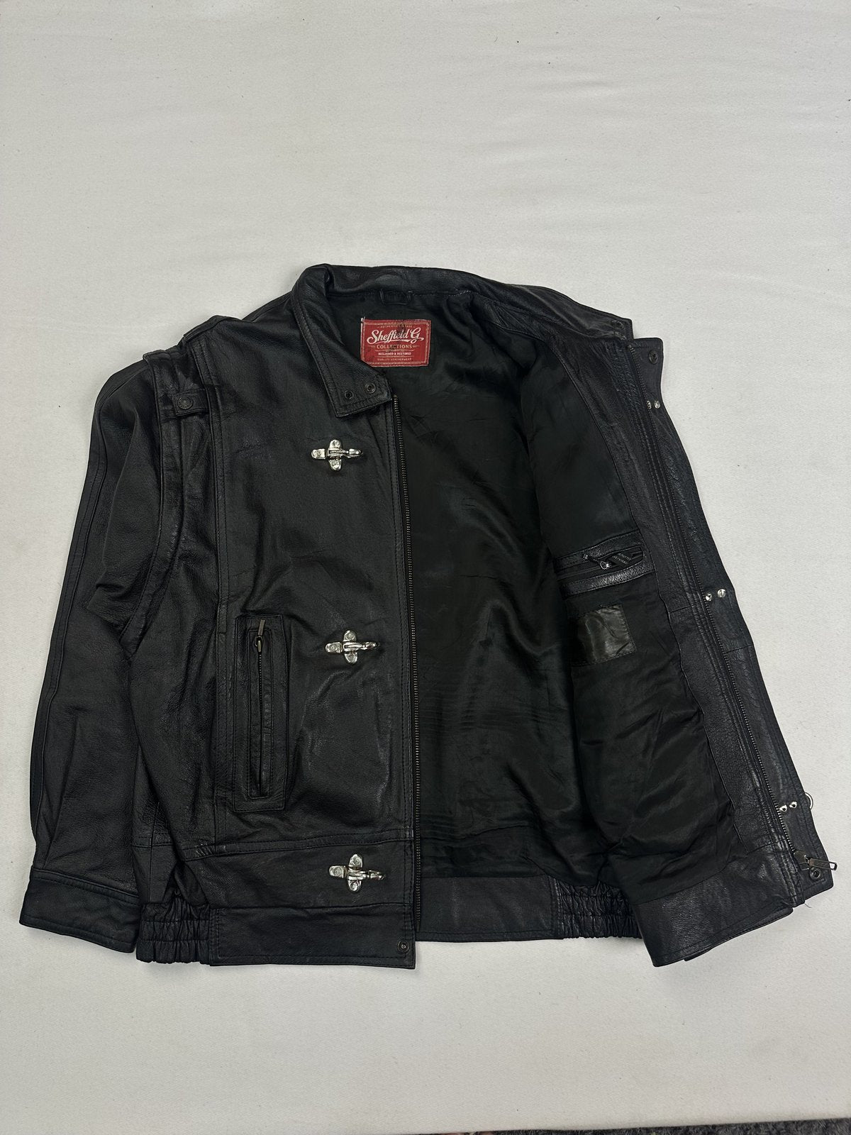 Interior of the XL black jacket laid open with the clasps running down the front edge