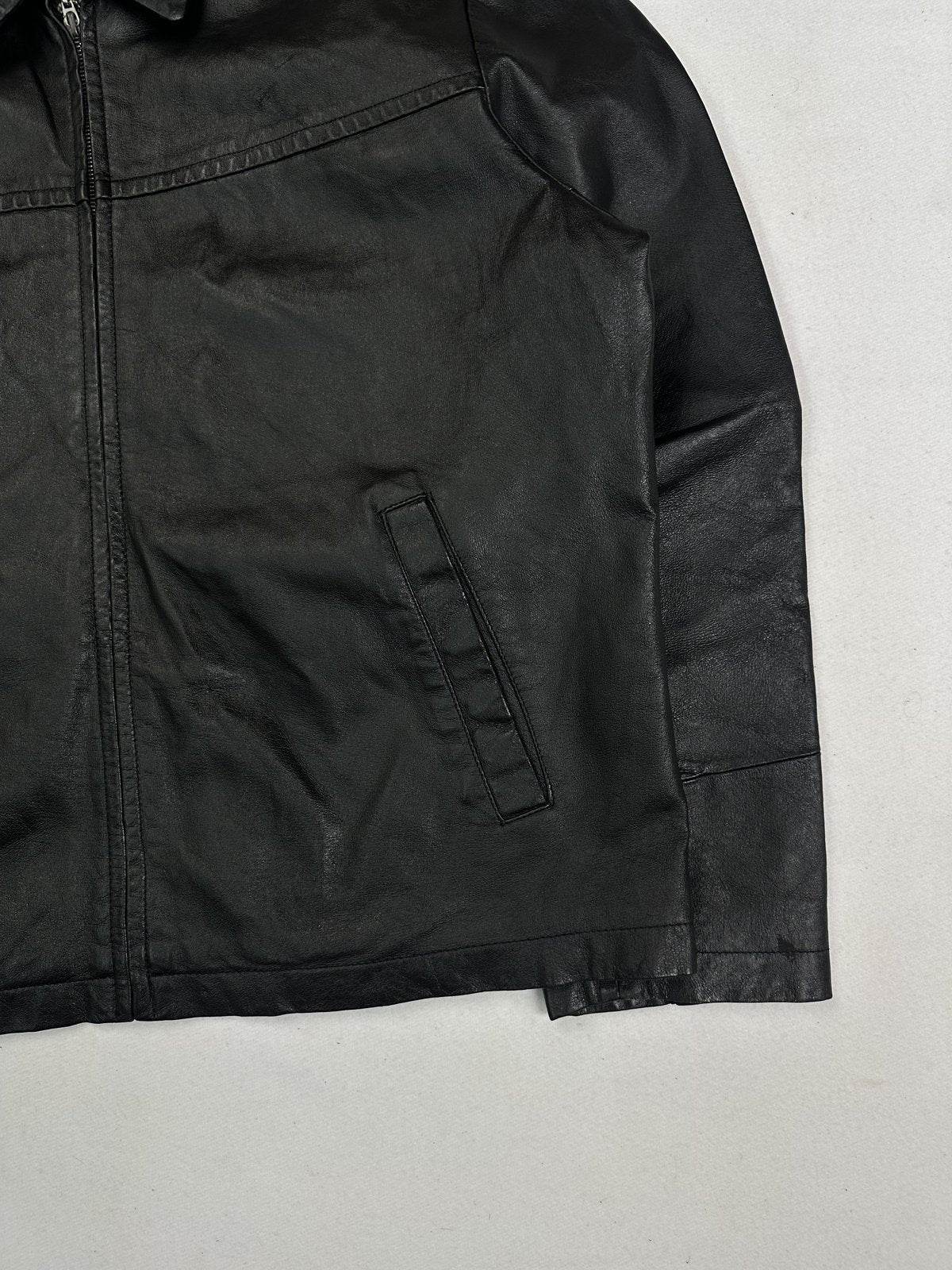 Close view of the front zip and welt pocket beside the plain sleeve cuff