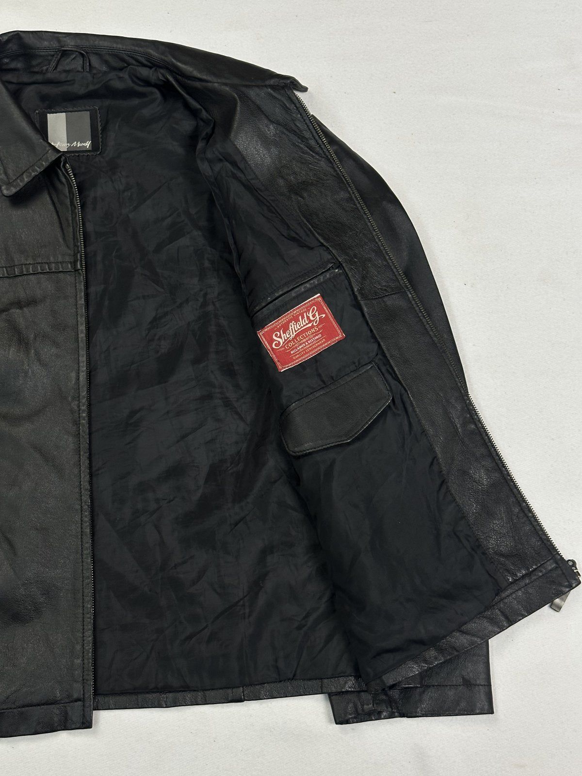Black jacket held open to show the lining and an inner flap pocket