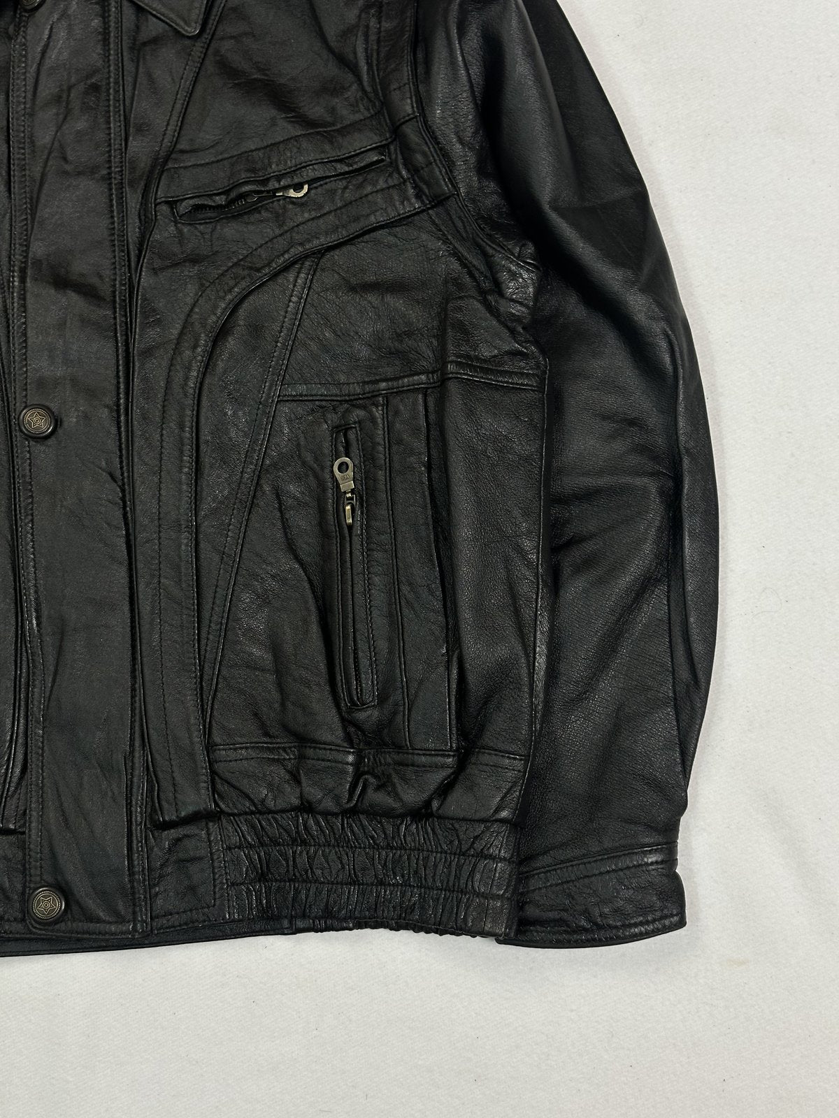 Angled view of the right side zip pocket and shirred waistband on the black leather