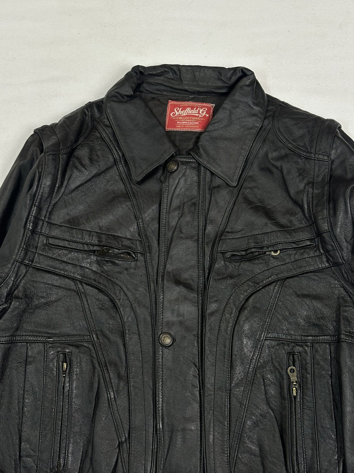 Close view of the shirt collar and the brass snap studs down the front placket