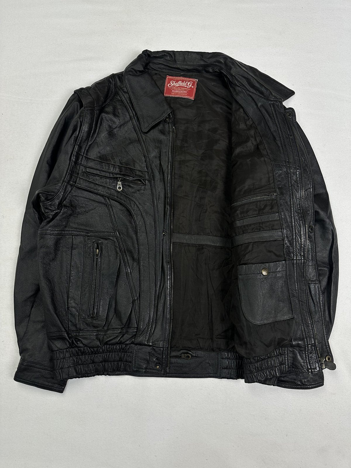 Black lining inside the XL leather bomber, held open to show the interior