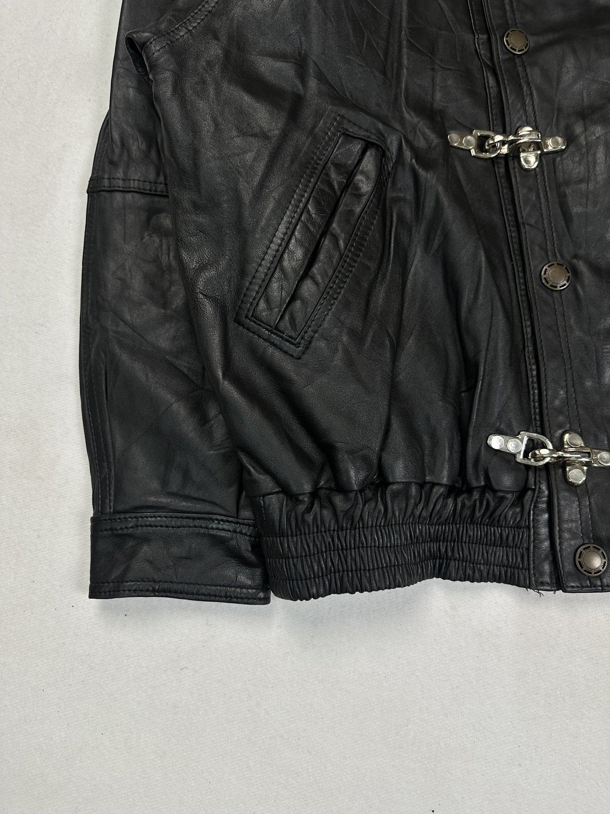 Lower front corner with a flap pocket, the cuff and the gathered elasticated waistband