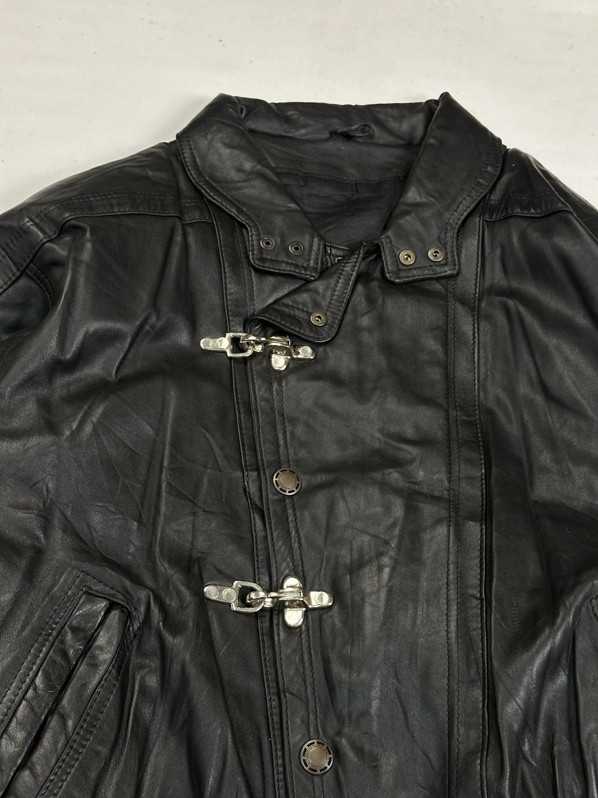 Close view of the snap-tab stand collar and the top clasp on this vintage black jacket