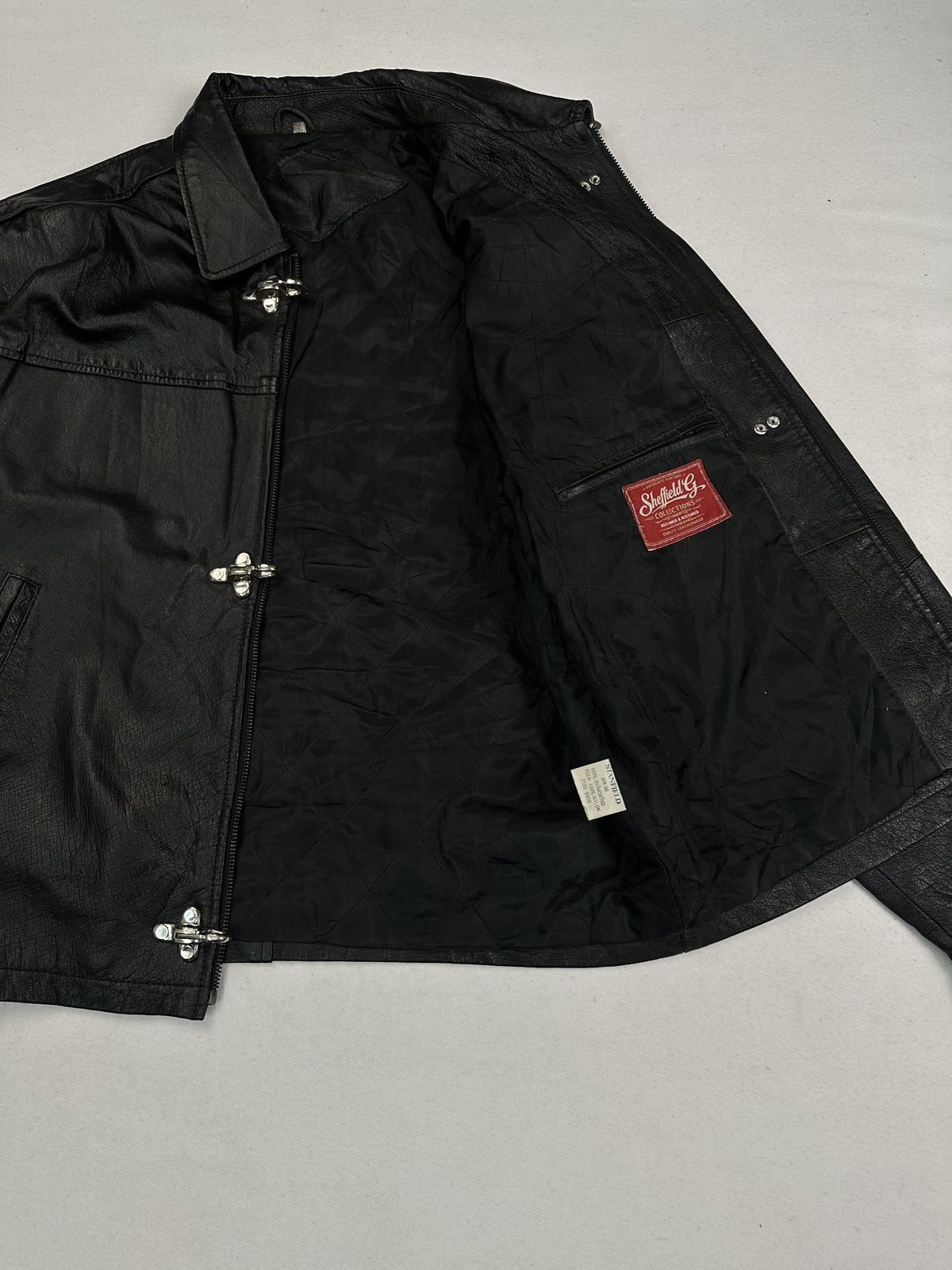 Jacket opened out flat to show the dark lining and the zip facing along the front edge
