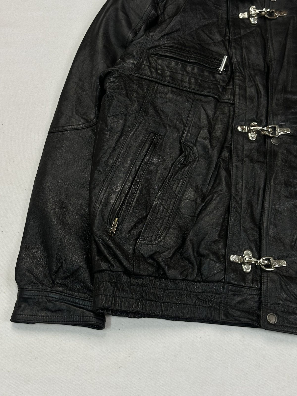 Lower corner showing the quilted zip pocket and the gathered hem on black leather
