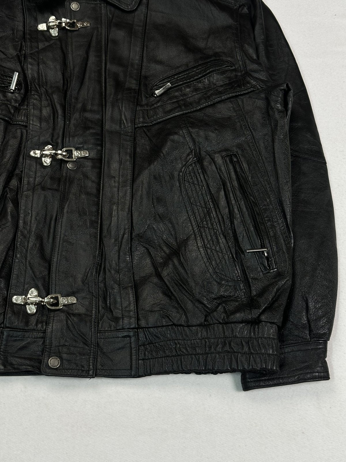 Angled view of a padded zip pocket beside the row of silver clasp fastenings