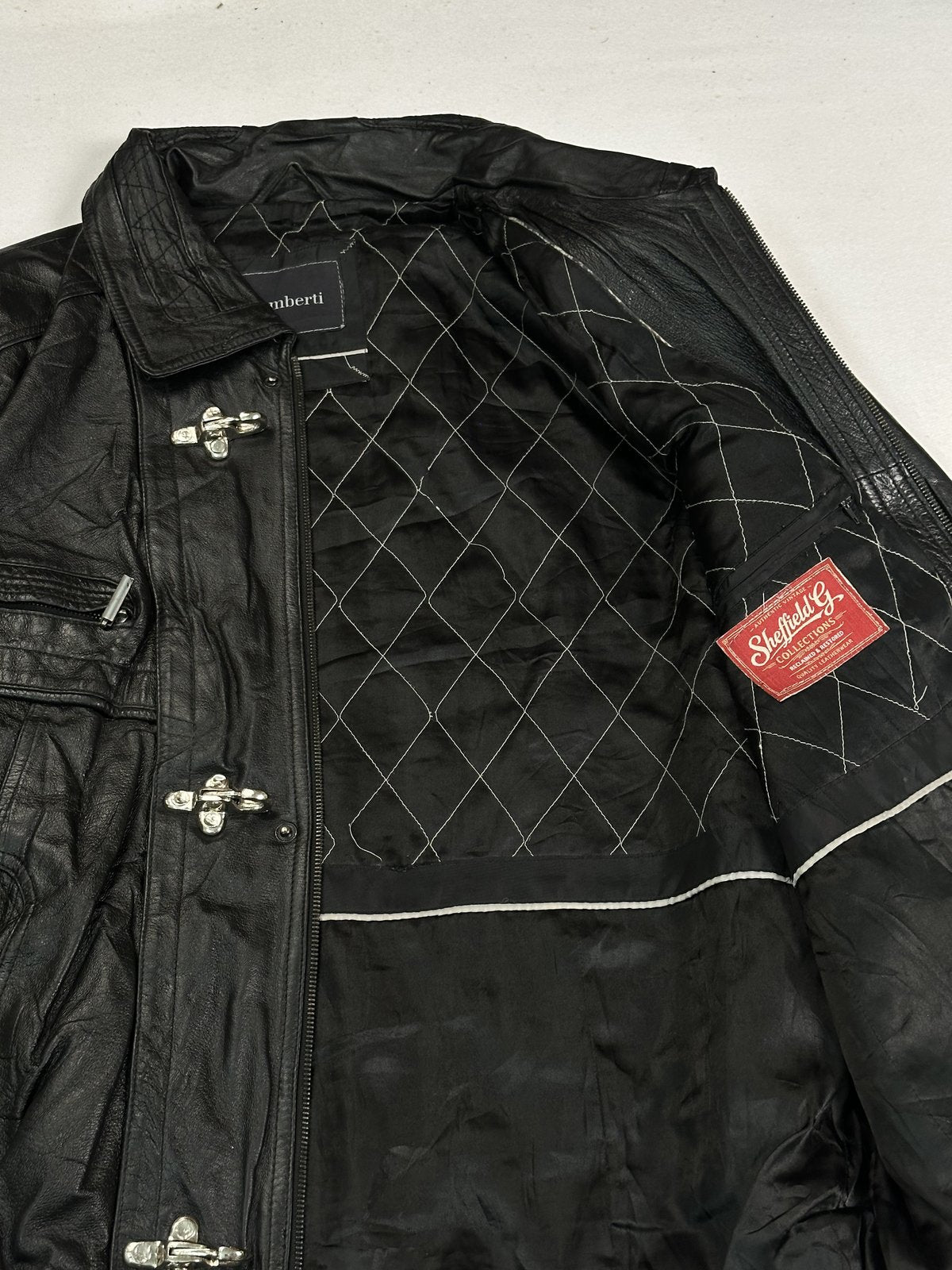 Close view of the diamond stitching on the quilted lining inside the black jacket