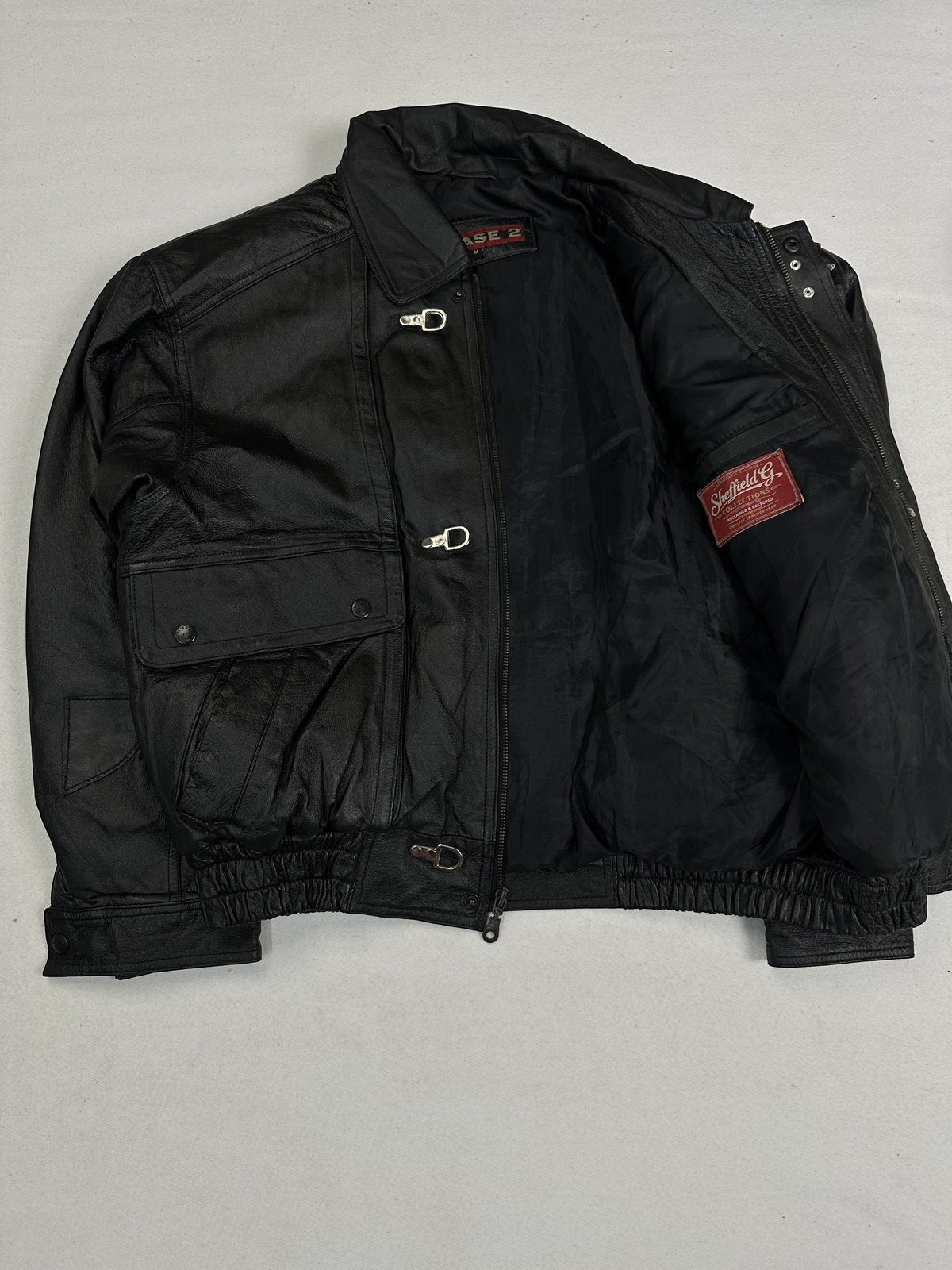 Flap pockets fastened with studs on this size XL black leather jacket