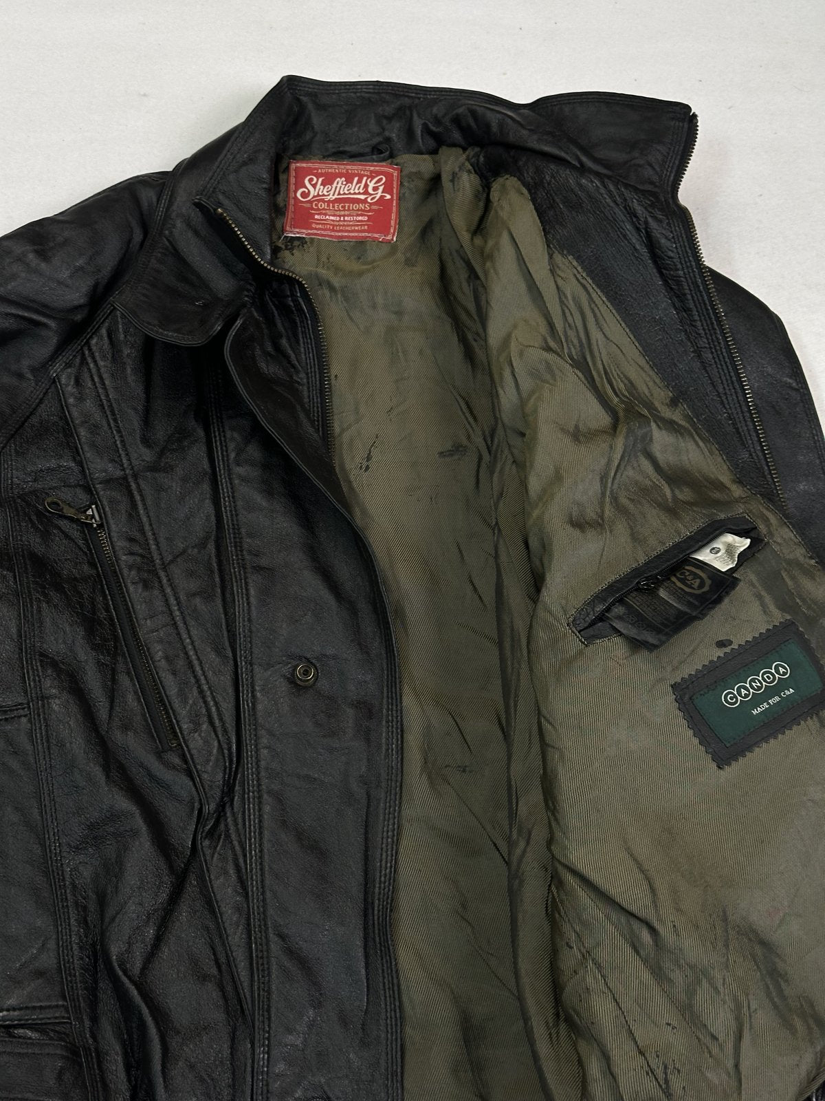 Olive green lining and inner pocket inside the black bomber, held open