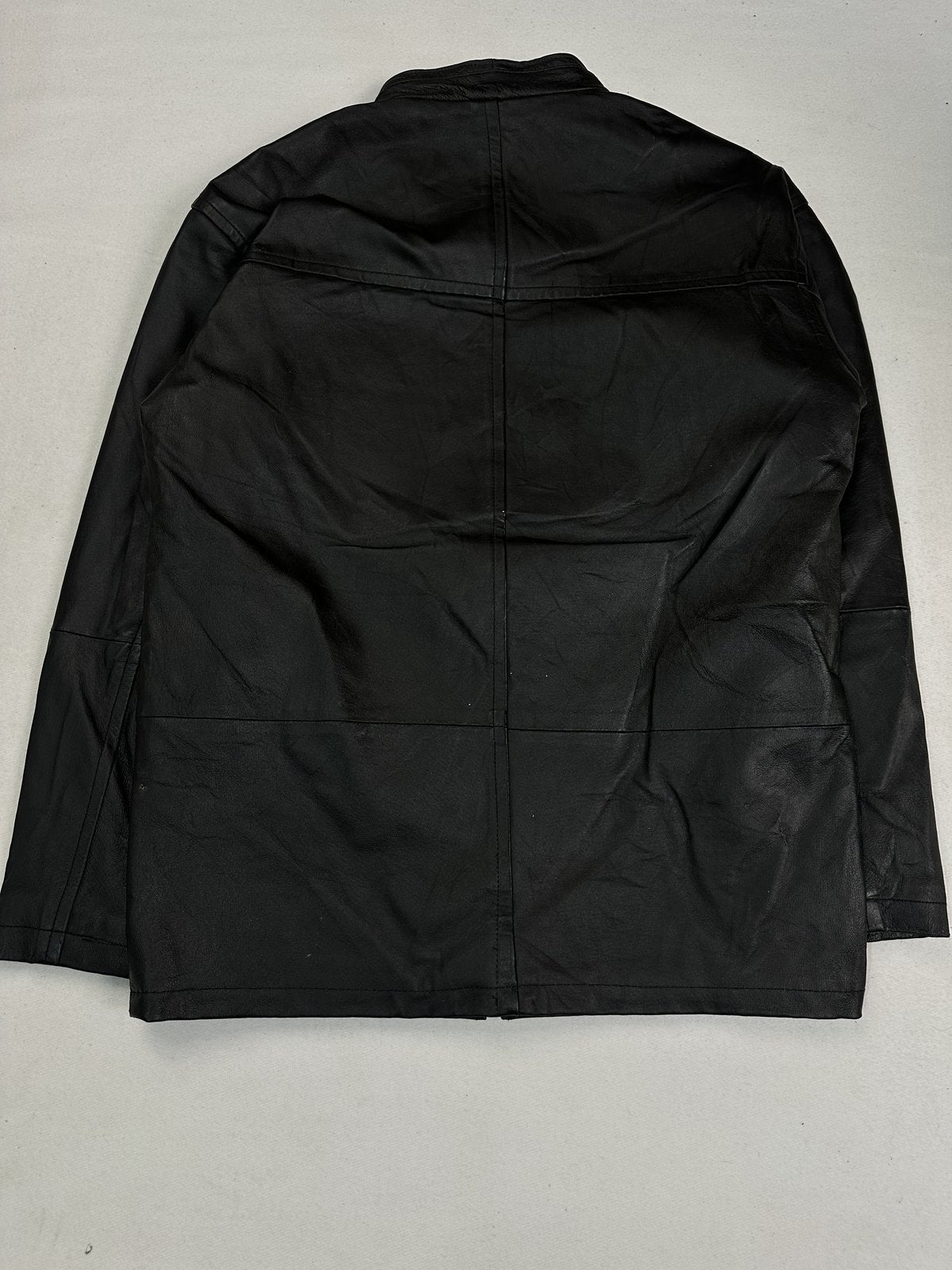 Back of the size L black jacket laid flat, showing the long panelled body and yoke seam