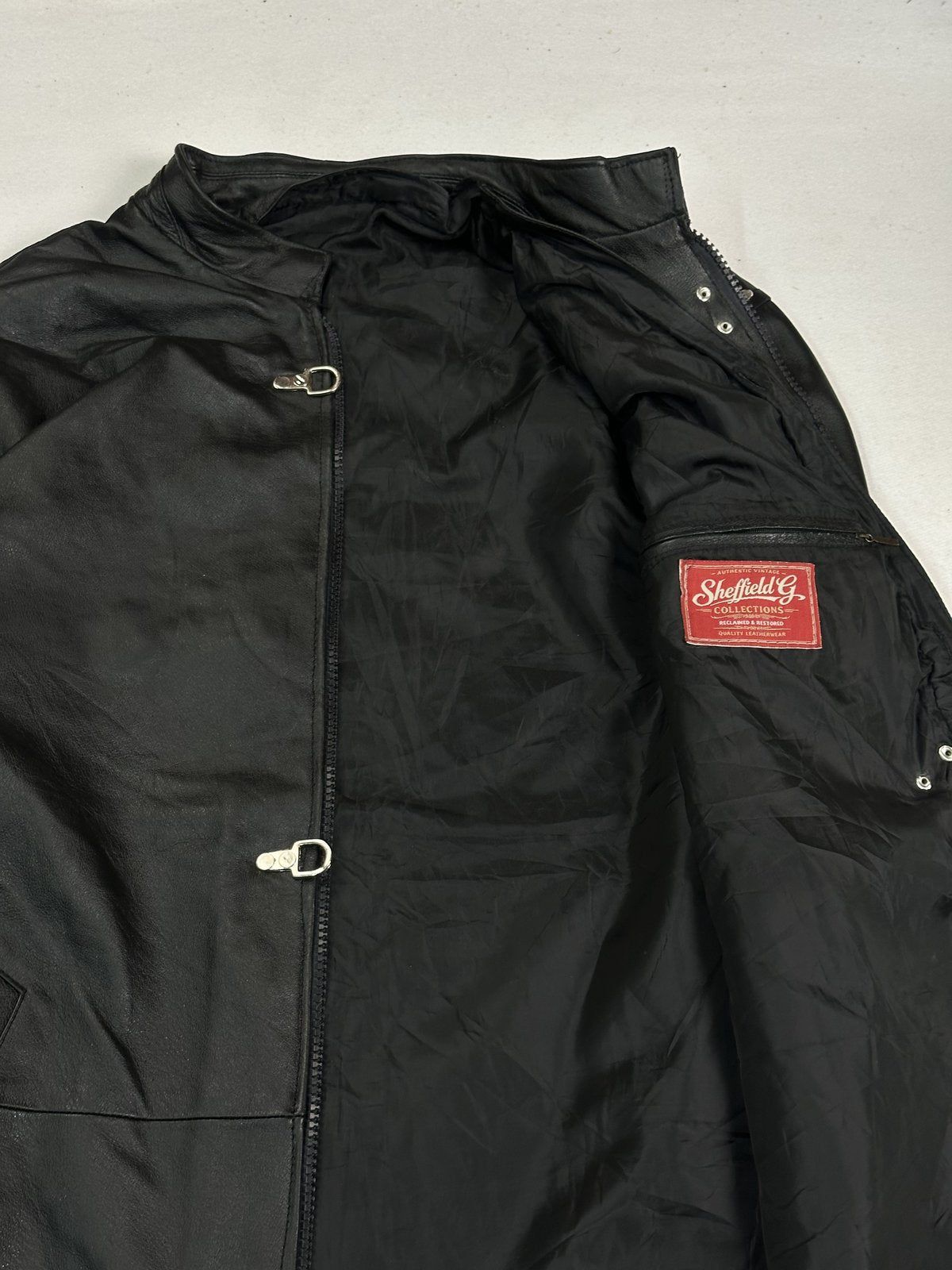 Detail of the red woven label and press studs inside the black lining