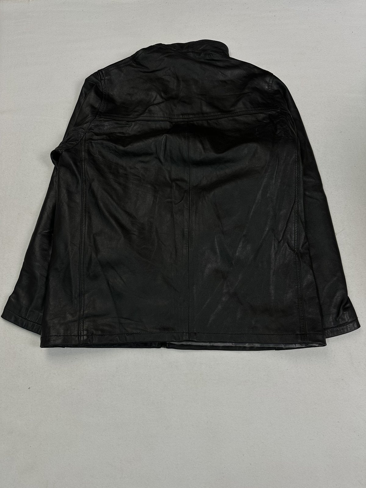 Fold-over collar standing at the neck of the black leather cafe racer