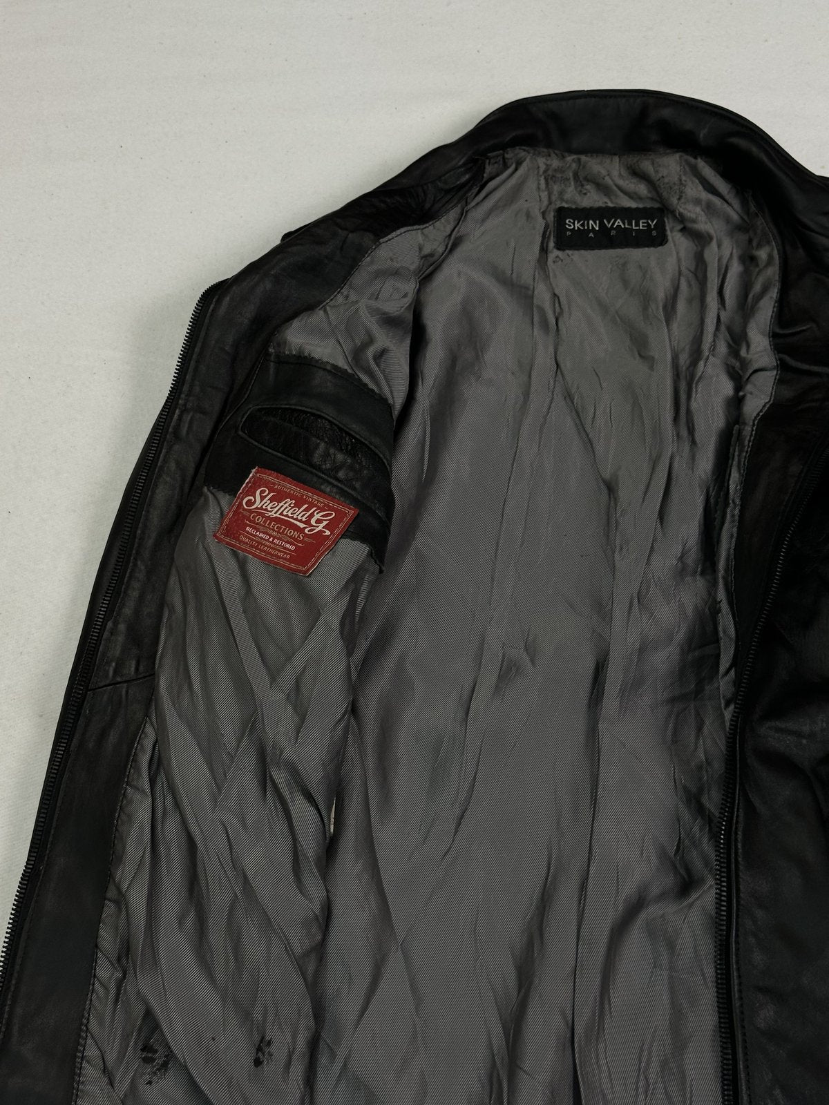 Soft black leather across the body of this size L cafe racer jacket