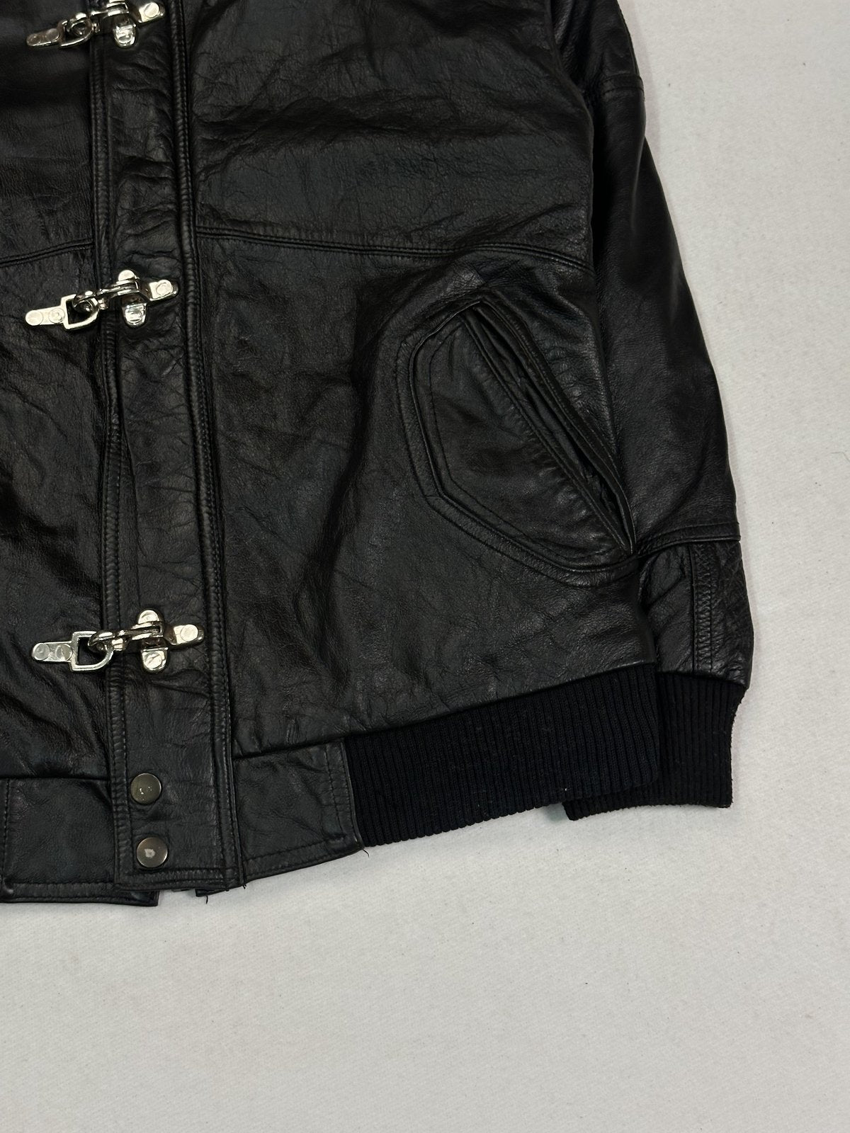Knitted cuff at the end of the sleeve on this black leather bomber