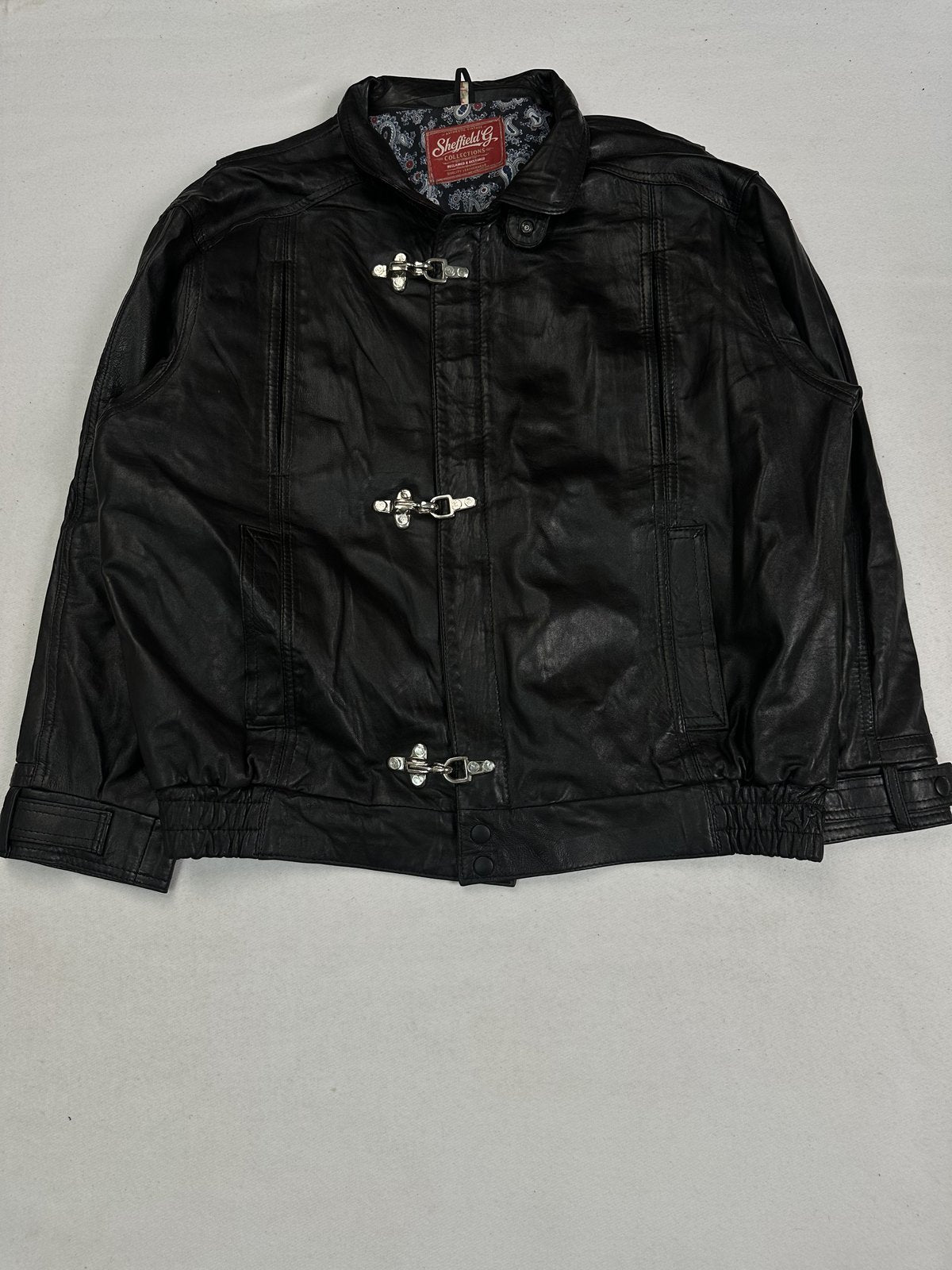 Black leather vintage jacket in size XXL shown from the front with three silver clasps