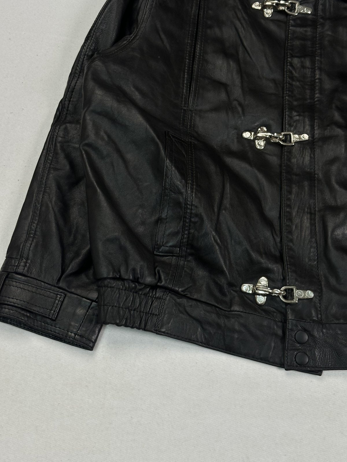 Lower front corner with a welt pocket, press studs and the gathered elasticated hem